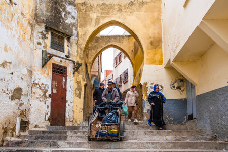 Casablanca, Morocco â April 19, 2025: Street scene in the old medina showing people walking and shopping along a lively alley with traditional architecture and arched doorways. The image captures the vibrant daily life and cultural atmosphere of this historic North African city, blending tradition and modern urban energyの写真素材