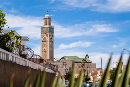 Hassan II Mosque, Casablanca, Morocco â The majestic Hassan II Mosque stands on the Atlantic coast in Casablanca, Morocco, under a bright blue sky. Its tall minaret, ornate arches, and intricate Moroccan architectural details reflect in the ocean below, creating a serene and impressive view of one of the largest mosques in the world.の写真素材