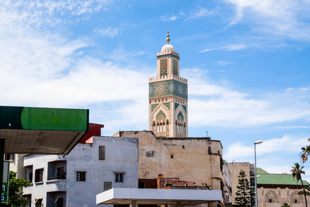 Hassan II Mosque, Casablanca, Morocco â The majestic Hassan II Mosque stands on the Atlantic coast in Casablanca, Morocco, under a bright blue sky. Its tall minaret, ornate arches, and intricate Moroccan architectural details reflect in the ocean below, creating a serene and impressive view of one of the largest mosques in the world.の写真素材