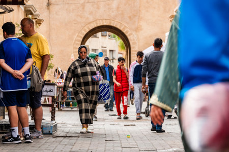 Casablanca, Morocco â April 18, 2025: Street scene in the old medina showing people walking and shopping along a lively alley with traditional architecture and arched doorways. The image captures the vibrant daily life and cultural atmosphere of this historic North African city, blending tradition and modern urban energyの写真素材