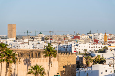 Rabat, Morocco â A quiet narrow alley in the historic medina of Rabat, lined with whitewashed buildings, traditional wooden doors, and decorative street lamps. The cobblestone street leads toward small local shops displaying colorful fabrics, creating an authentic atmosphere that reflects Moroccan architecture and daily life in the old city.の写真素材