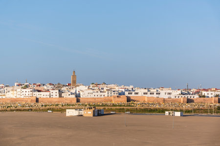 Rabat, Morocco â A quiet narrow alley in the historic medina of Rabat, lined with whitewashed buildings, traditional wooden doors, and decorative street lamps. The cobblestone street leads toward small local shops displaying colorful fabrics, creating an authentic atmosphere that reflects Moroccan architecture and daily life in the old city.の写真素材