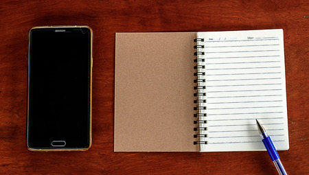notebook with telephone on wood backgroundの写真素材