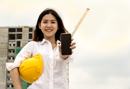 engineer or foreman using smart phone in her job with in construcktion siteの写真素材