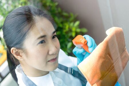 Asian women maid Glass cleaner in homeの写真素材