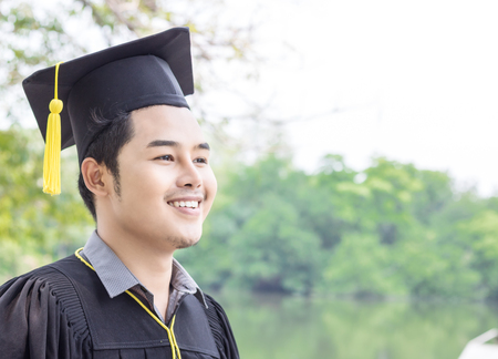 Asian man student graduate  in public parkの写真素材