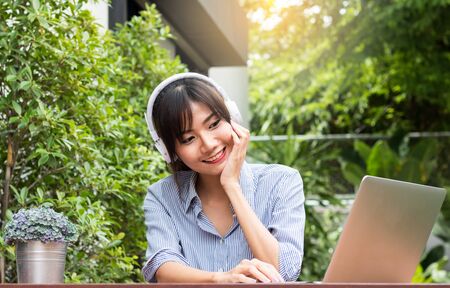 beautiful Asian women Listen to music and work  job on labtop with drink coffee in morningの写真素材