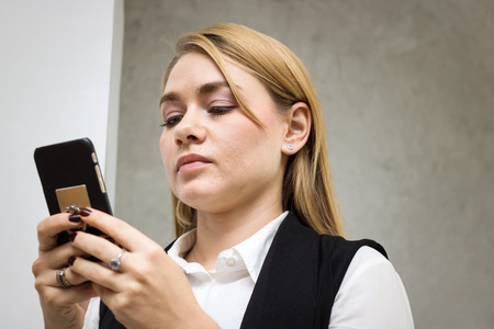 business women play smart phone in officeの写真素材