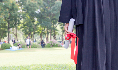 student graduate holding certificated in hand with in the gardenの写真素材