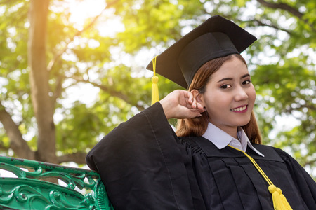 Asian female student graduate  in public parkの写真素材