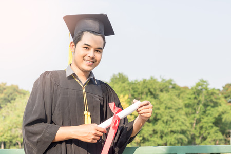 student graduate holding certificated in hand with in the gardenの写真素材