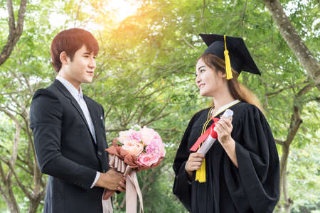 graduated Asian male student  Get flowers from friend celebratingの写真素材