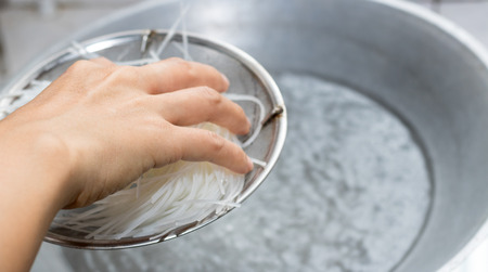 scald noodles with boiled water in potの写真素材