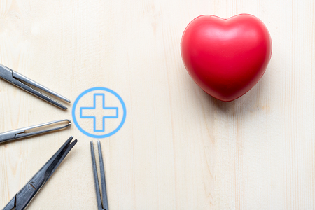 red  pillow heart and scissors for doctor  on wood tableの写真素材