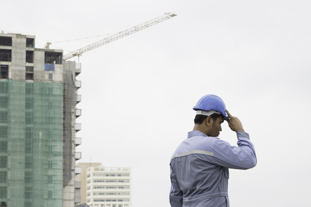 engineer or foreman holding hard cap on construction site
