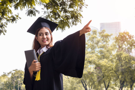 student graduate holding book and point buildingの写真素材