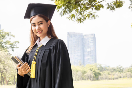 student graduate holding book in the gardenの写真素材