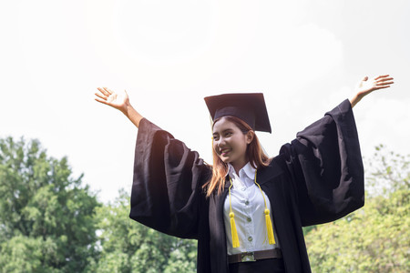 Asian female student graduate  in public parkの写真素材