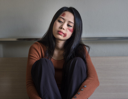 Sad girl sitting on the floor in corner of room.Unhappy depressed teenagerの写真素材