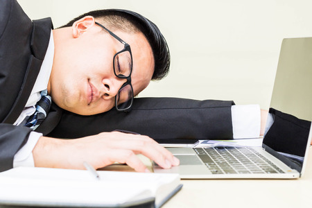 business man sleep on desk in office with after work hardの写真素材