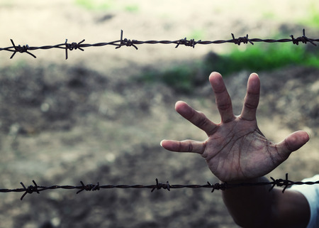 man hands hold the rusty sharp bare wire with hope longing,Human rights conceptの写真素材
