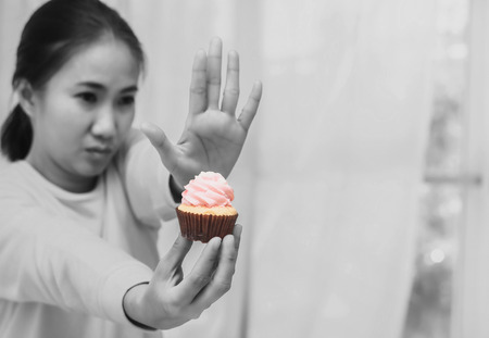 Asian woman on dieting for good health concept.say no cup cake and junk food.color toneの写真素材