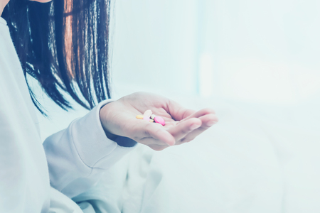 Asian women take a medicine on bed.color toneの写真素材