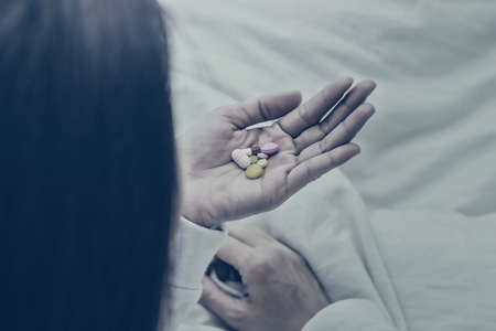 Asian women take a medicine on bed.color toneの写真素材