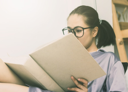 women read book to learning on bed in bed room in the morningの写真素材