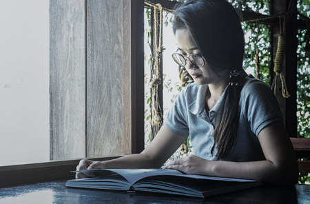 women read book to learning on bed in bed room in the morning.color toneの写真素材
