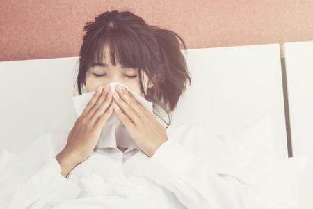 Asian woman sick sleep on  white pillow on bed in bedroom in holiday.の写真素材