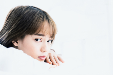 Asian woman wake up on bed in bedroom in the morning.at home in holiday.color toneの写真素材