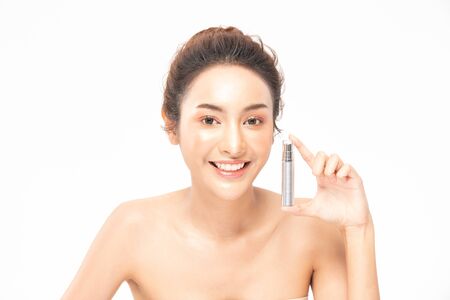 Beauty asian woman  brown hair looking smile in camera happiness and hold bottle cosmetic cream lotion  and cheerful with make up brush,Beauty Concept on white background.の写真素材