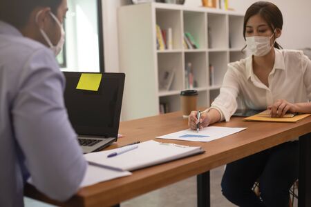 Asian business man and women talk about job and wear masks.New nomalの写真素材