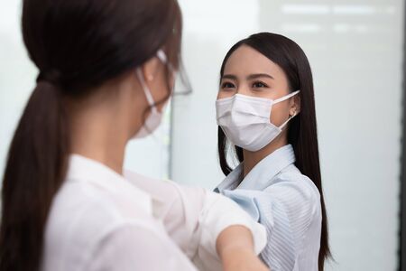 business woman wering mask use elbow hello instead of hand shake.の写真素材