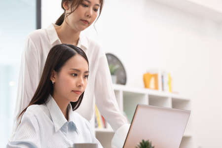 Asian business women talk and use laptop for job.の写真素材
