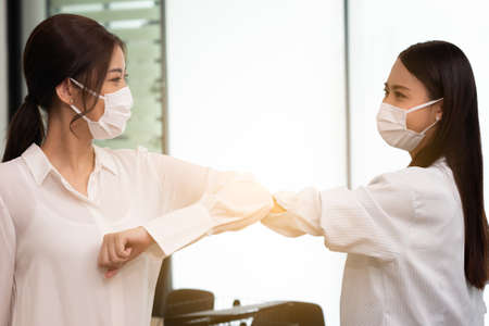 Business woman wering mask use elbow hello instead of hand shake.の写真素材