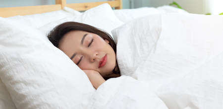 Asian women sleeping and sweet dream on white bed in bedroom
