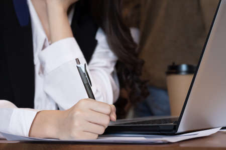 Close up hand business women note job  on graph in business meeting.の写真素材