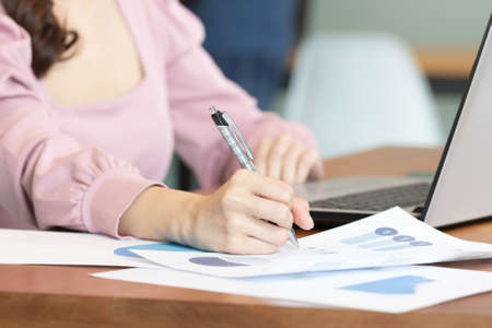Close up hand business women note job  on graph in business meeting.の写真素材