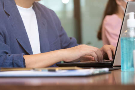 Close up hand man type job on labtop and talk job in business meeting