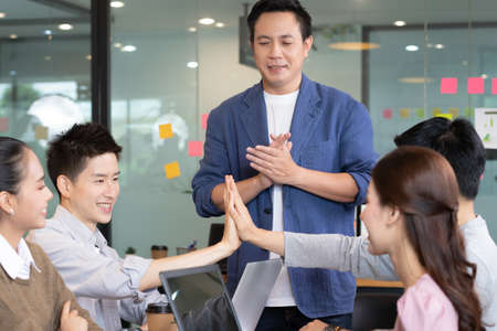 Business man and woman join hands for branding in office.