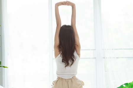 Asian woman wake up on bed in bedroom in the morning.の写真素材