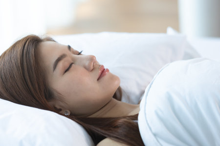 Asian women sleeping and sweet dream on white bed in bedroomの写真素材