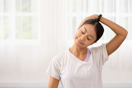 Asian woman exercises In the fitness studio, practice neck stretching and meditation for better health.の写真素材