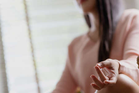 Morning yoga with an Asian woman, sitting in Easy position, Sukhasana posture, and meditating online.の写真素材