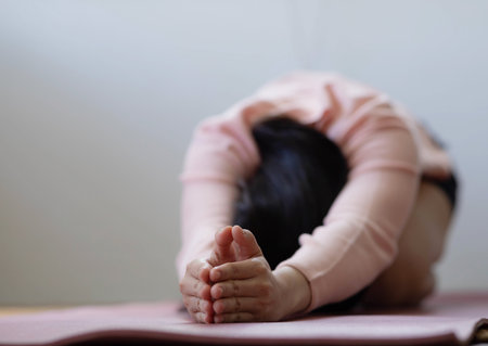 Cloese up hand.Asian woman working out in sportswear while doing yoga, seated in Child exercise, Balasana stance.の写真素材