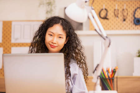 Asian woman designer sitting and thinking about design in the morning at home.