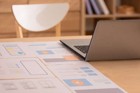 At home, a business asian man types and works online on a desk table with a laptop.