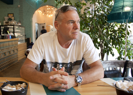 a man of age sitting in a cafeの写真素材
